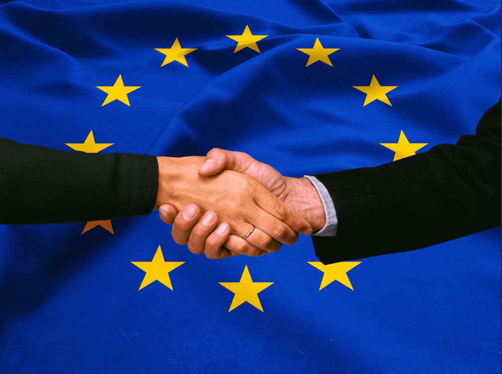 Ludia si podávajú ruky, vlajka Europskej únie v pozadí